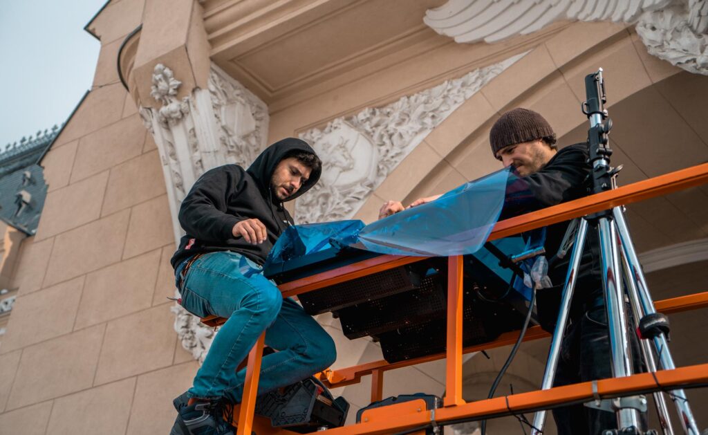 Echipa de filmare pregătind un cadru pe un balcon, la locație